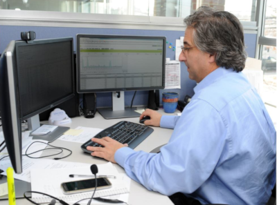 Lincoln Computer Services office with a man sitting at a desk with three computer monitors, working.