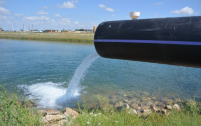 Wichita Falls Texas. A large pipe on the right with water running out of it into a pond or lake.