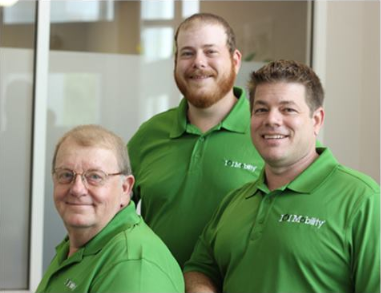Franchise Business Review. 3 Employee pose for a photo all wearing the same uniform.