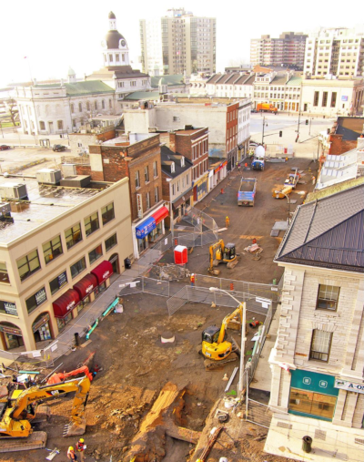 Kingston Ontario. Aerial view of construction on a city street with multiple excavators and work vehicles.