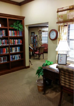 The Inn at University Village, a view of a desk on the right and a bookshelf on the left, with a room beyond the walk-through.