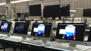 PowerON. Computers in a row on a desk with more monitors visible behind.