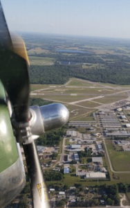 The Bartow Municipal Airport. Viewing the prop of an engine while in flight, with a city below.