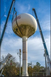 Phoenix Fabricators & Erectors. A water tower being lifted by multiple cranes.