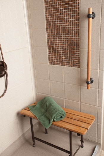 bestbath shower with recessesd tile and a teak bench.