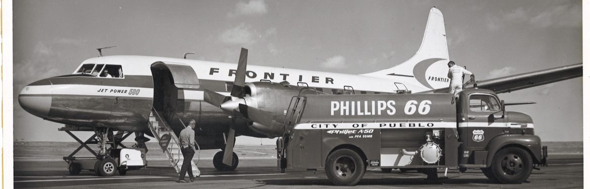 Pueblo Memorial Airport, old black and white photo of an old Frontier passenger plane getting refueled on the runway.