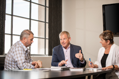 David Jones of Keller Williams Southern Arizona talks with two people at a table.