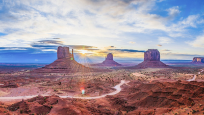 United States Environmental Protection Agency. Photo of mesas out west in the US with blue sky and scatted clouds, with the sun shining through.