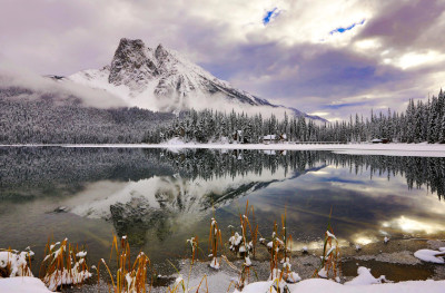 Columbia Shuswap Regional District British Columbia; A mountain in the background with a lake in front and the mountain and trees reflecting on the water.