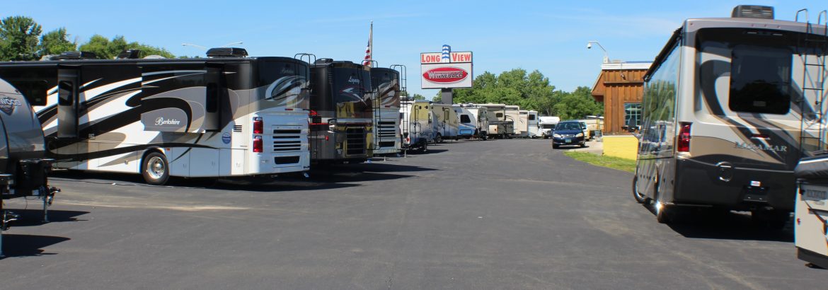 Long View RV SuperStores, a view of their vehicles with their sign in the middle of the background in this image.
