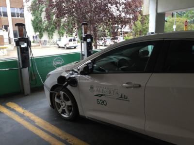 The University of Alberta. An Electric Vehicle (EV) parked and plugged into a charging station.