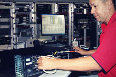 Worldwide Supply; an employee testing a device.