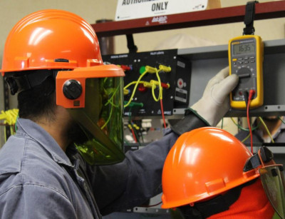 Airstreams Renewables. People with safety gear using electronic testing devices.