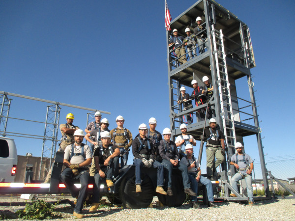 Airstreams Renewables Class Graduation with men sitting in front of the tower and some standing on each level.
