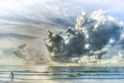 Bay County Florida, clearwater beach with a child playing and lovely clouds.