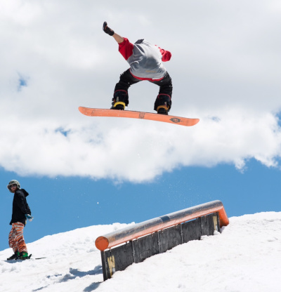 Innegra Technologies. Mike Sears snowboarding in the air about to land on a rail.