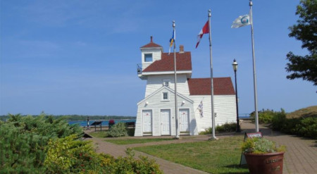 The Region of Queens Municipality. An older looking building with 3 flag poles out front.