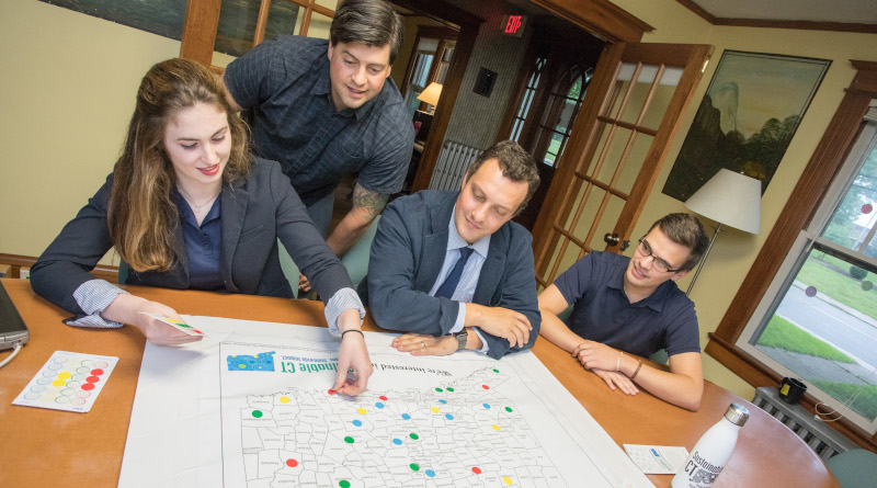 Sustainable CT, four people putting stickers on a map.