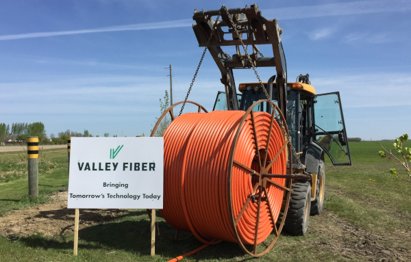 Winkler, Manitoba. Valley Fiber sign and a vehicle with a large spool of wire.