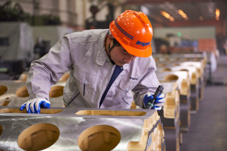 Impro Industries, worker inspecting what looks like an engine block.