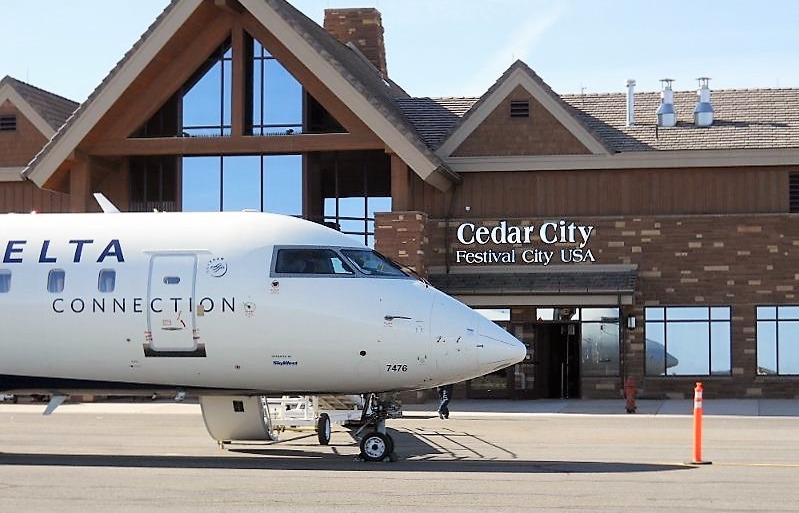 Cedar City Regional Airport with plane parked in front of building.