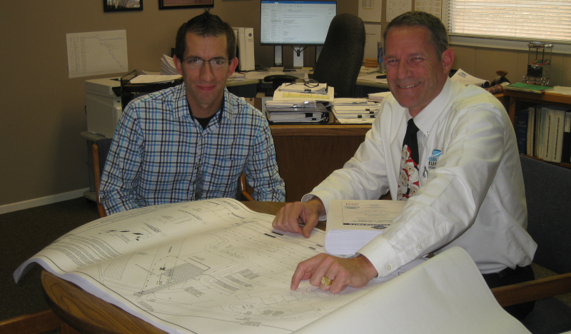 Crater Lake-Klamath Regional Airport. Joe Goetz and John Barsalou sitting at a table looking over a document.