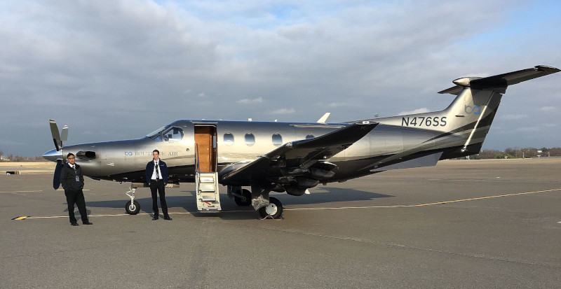 Cavern City Air Terminal Boutique Air plane on runway with two men in suits.