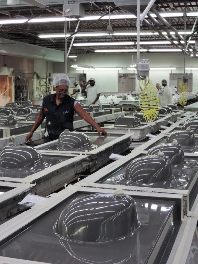 The International Cast Polymer Association. Factory with upside sinks being worked on by employees.