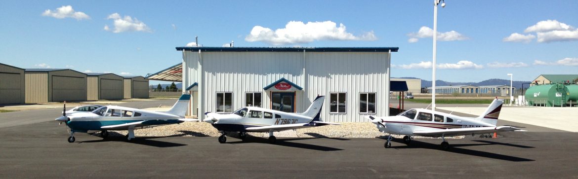 Deer Park Air Center building with 3 small aircraft parked in front in a row.