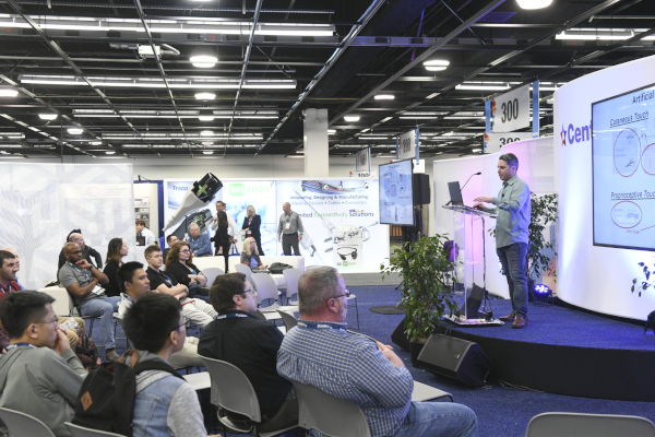 MD&M West Expo. A man speaking in front of people sitting in chairs at an event.