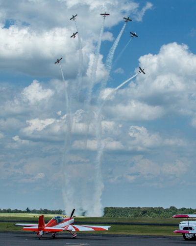 The North Little Rock Municipal Airport airshow with airplanes in formation and smoke trails.