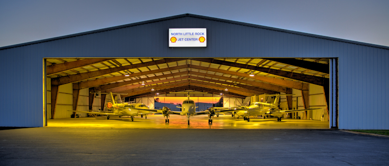 The North Little Rock Municipal Airport Jet Center hangar at night with aircraft inside.