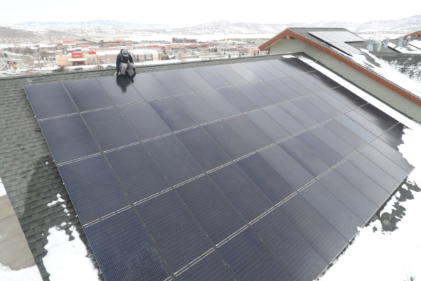 Summit County, Utah solar roof in winter with a worker on the rooftop.