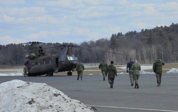 Auburn-Lewstion Airport Chinook helicopter with crew walking towards it on the runway.