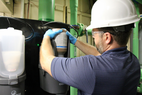 Chem-Aqua employee changing out a container of material.