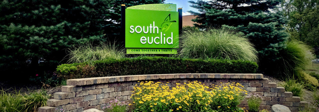 South Euclid Ohio sign on a short landscaping wall with plants and trees behind.
