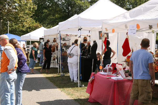 Logansport, Indiana market with booths set up and people walking around looking at the goods.