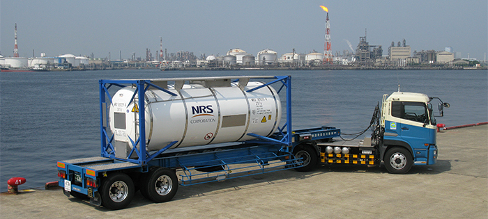 NRS Logistrics Inc, ISO Tank Container on a truck in front of a body of water.