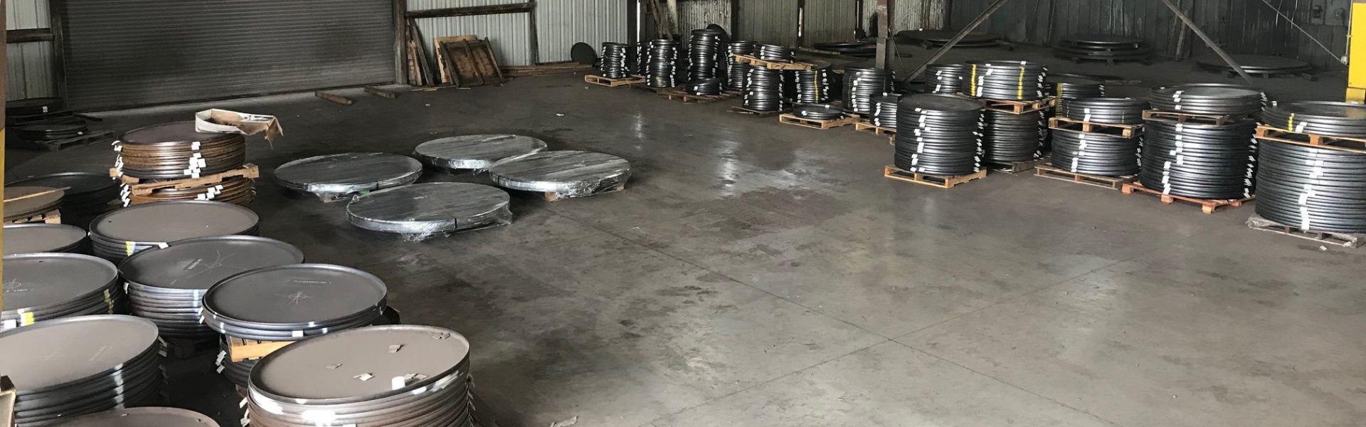 Shamrock Steel floor of warehouse with stacks of round steel parts.