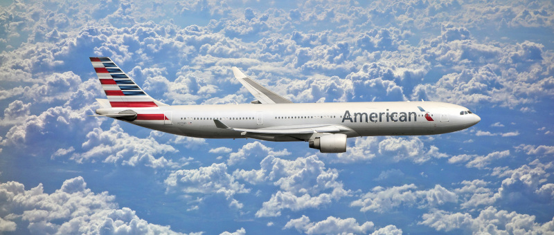 Del Rio International Airport. Stock photo of an American Airlines jet flying through white clouds.