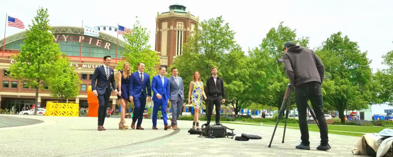 The Matt Laricy Group, group photo of a photographer taking photos in front of a stadium.