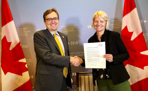 The Ministry of Fisheries, Oceans, and the Canadian Coast Guard Jonathan Wilkinson shaking hands with a woman holding up a statement of support.