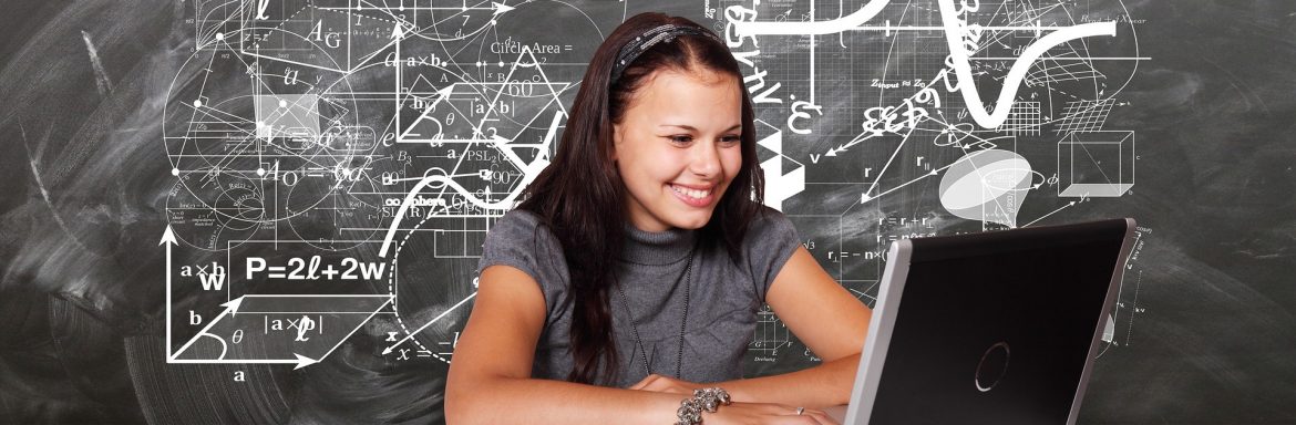 A young woman sitting at a laptop with a chalkboard behind her with math and geometry on it. Winning Students Think Locally to Solve Global Issues in Lexus Eco Challenge