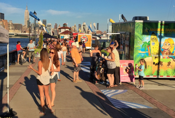 Hoboken, New Jersey Pier 13 with lots of people walking around and vendors selling treats.