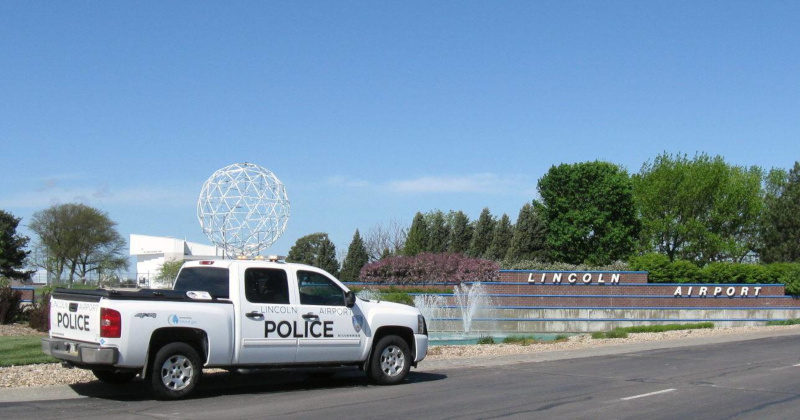 Lincoln Airport sign and a police truck parked next to it.