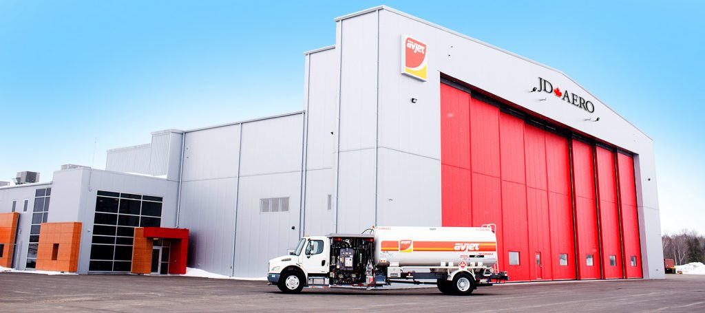 Sault Ste. Marie Airport hangar with JD Aero on the top of it and a fuel truck out front.