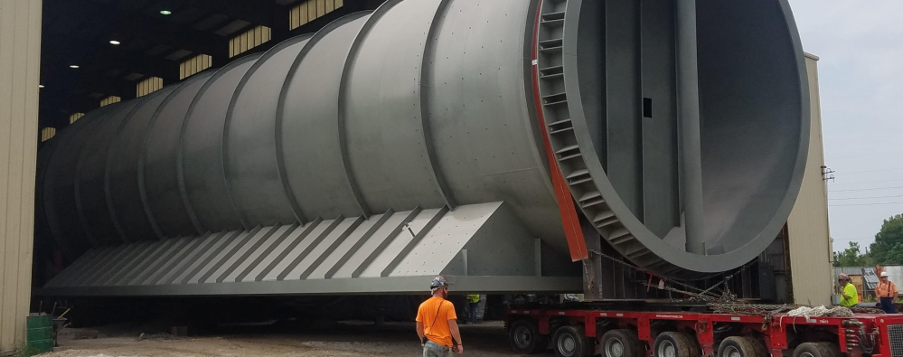 Great River Industries showing a very large fabricated item being wheeled out of a warehouse.
