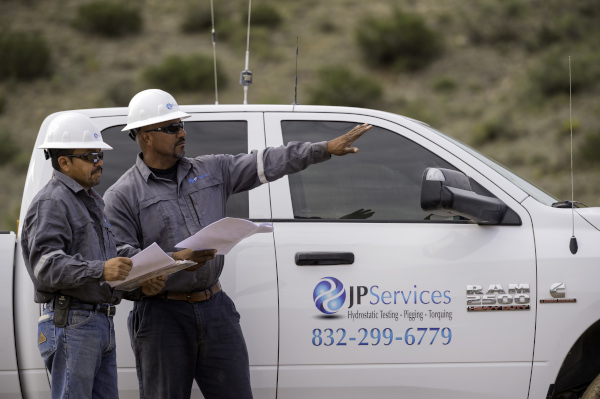 JP Services workers talking next to a truck.