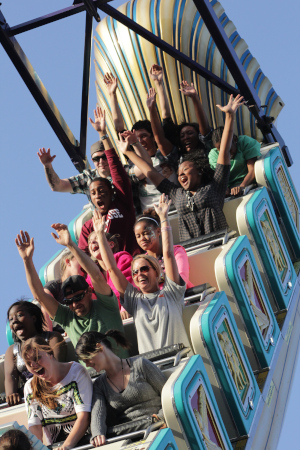 North Carolina State Fair, a group of people with their arms up and screaming going downwards on a roller coaster.