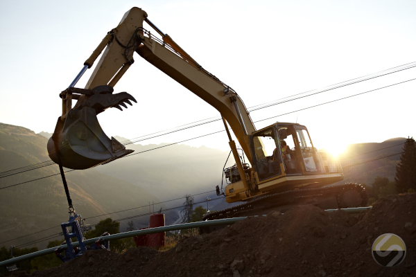 Peak Utility Services Group operating company Sitewise with an excavator helping stabilize pipes during hillside installation.